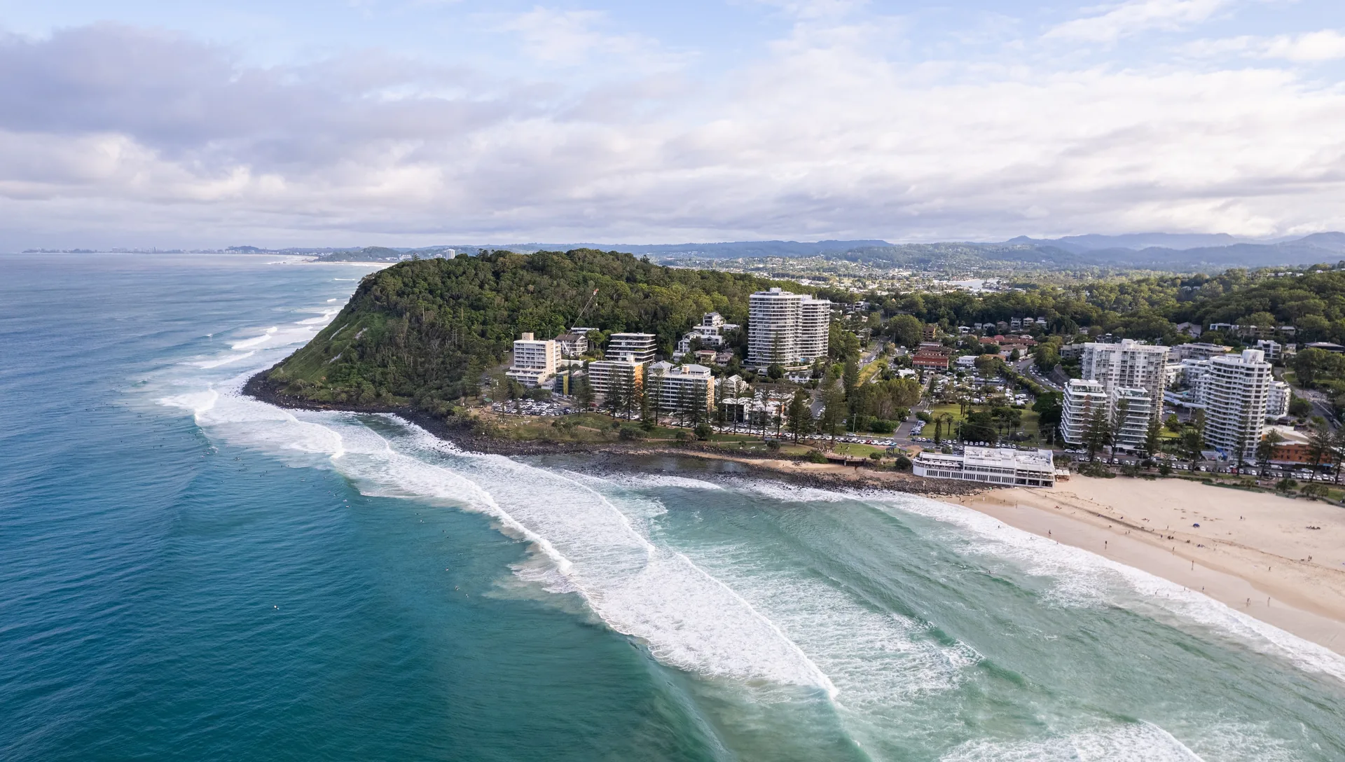 Aerial view of Burleigh Heads headland and beach with the Gold Coast skyline in the distance