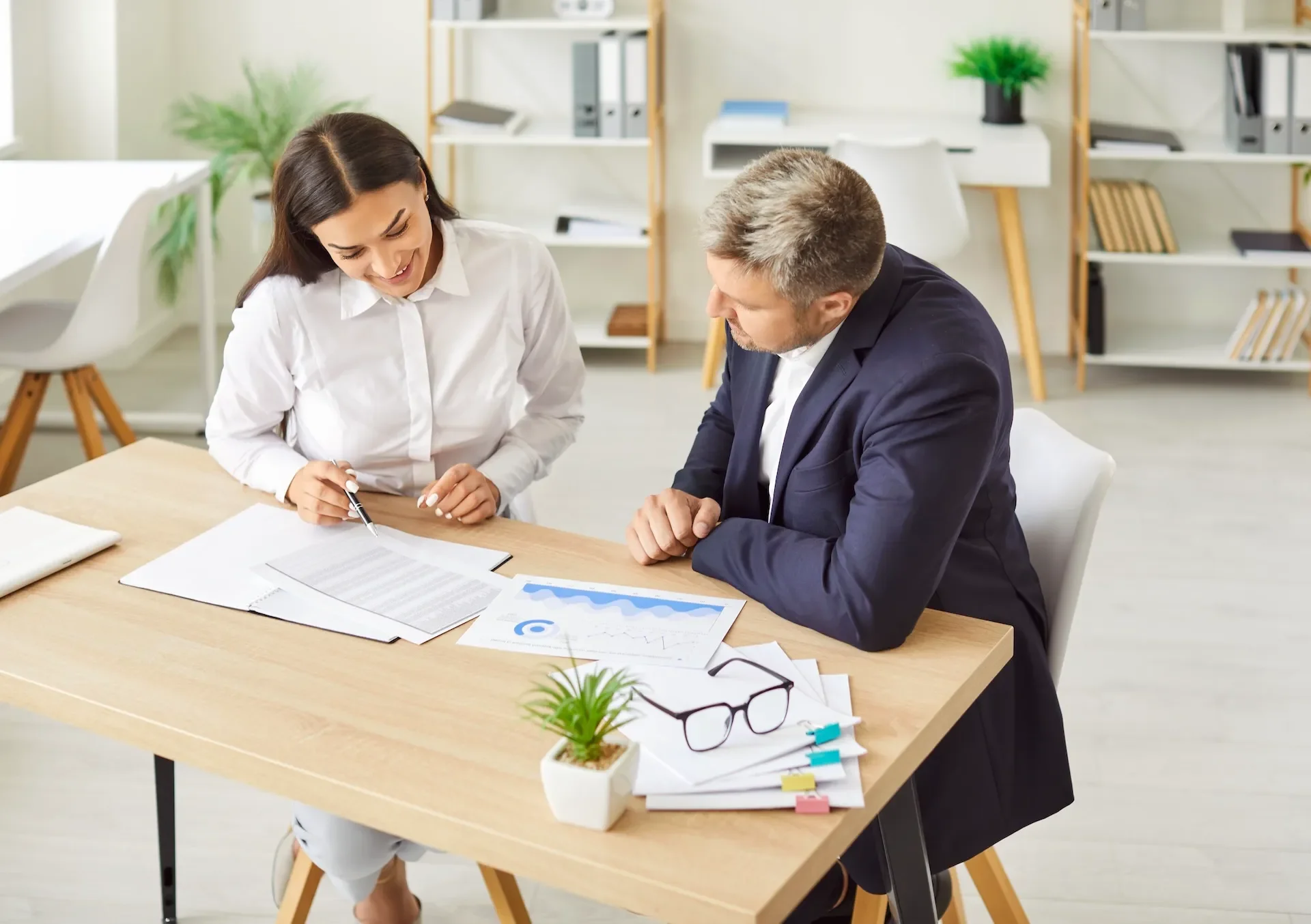 Bookkeeper going through financial reports with a Coomera business owner at a desk